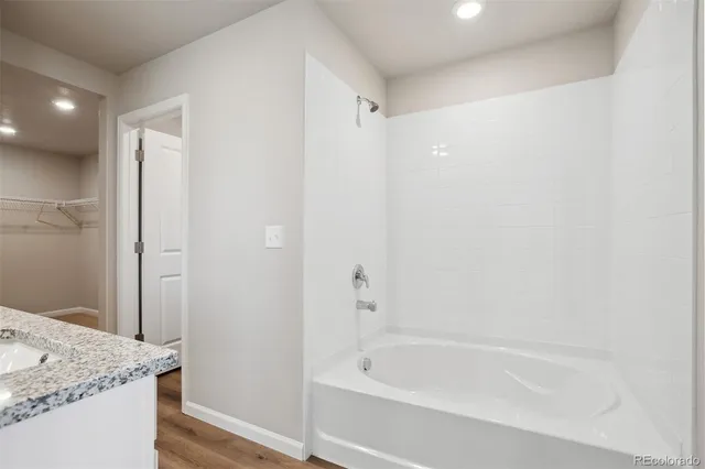 a bathroom with a granite countertop bathtub shower sink and mirror