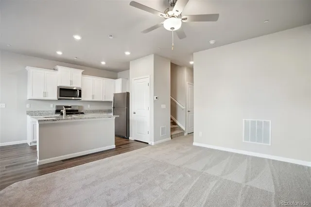 a view of kitchen with refrigerator stove microwave and cabinets