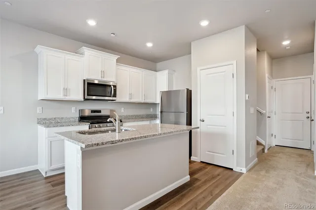 a kitchen with stainless steel appliances granite countertop a refrigerator sink and microwave