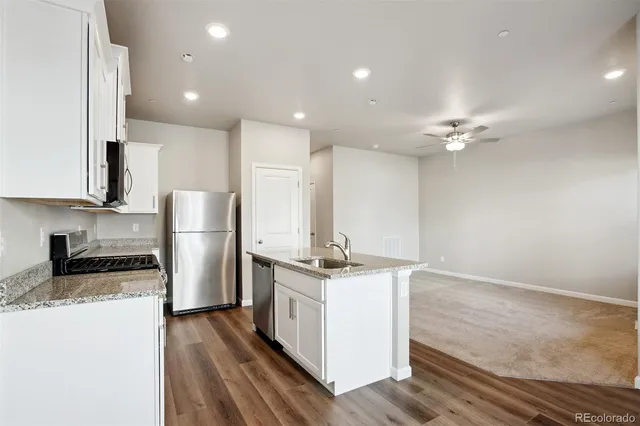 a kitchen with stainless steel appliances granite countertop a stove top oven a refrigerator a sink and dishwasher