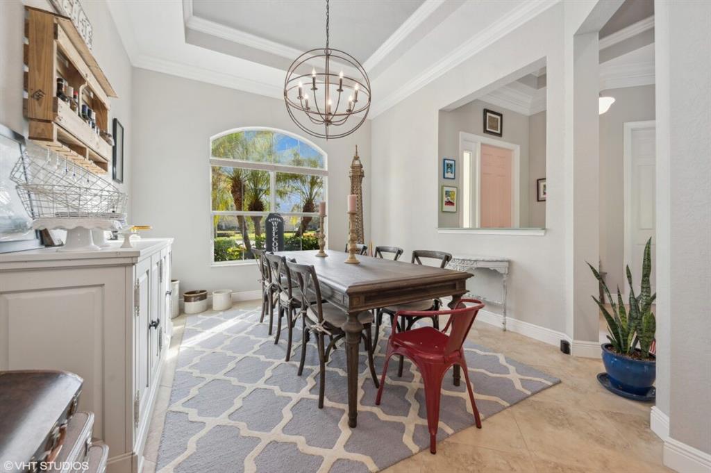 7619 Southeast Belle Maison Drive Stuart, FL 34997 - Photo 11 of 44 a view of a dining room with furniture a chandelier and wooden floor