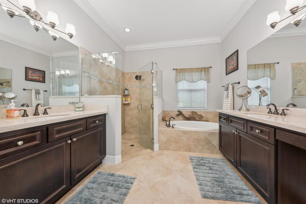 7619 Southeast Belle Maison Drive Stuart, FL 34997 - Photo 14 of 44 a large bathroom with a double vanity sink large mirror and a bath tub
