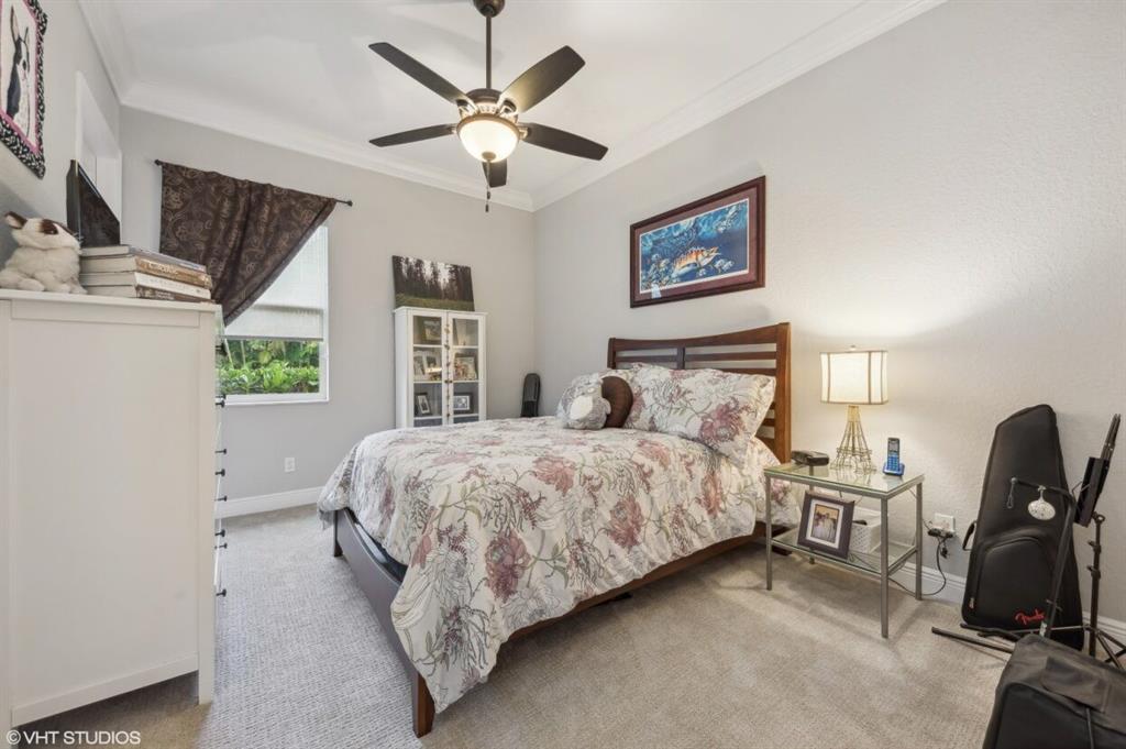 7619 Southeast Belle Maison Drive Stuart, FL 34997 - Photo 18 of 44 a bedroom with a bed and a chandelier