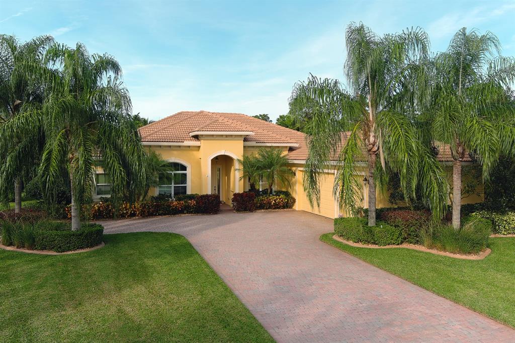 7619 Southeast Belle Maison Drive Stuart, FL 34997 - Photo 43 of 44 a front view of a house with garden