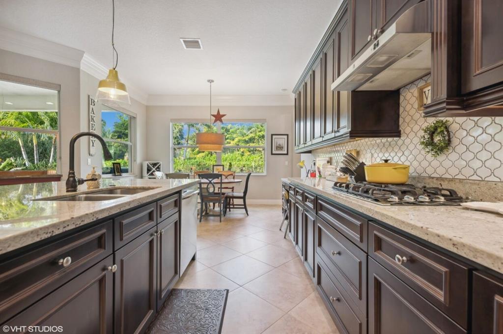 7619 Southeast Belle Maison Drive Stuart, FL 34997 - Photo 9 of 44 a kitchen with stainless steel appliances granite countertop a stove a sink and a wooden floors
