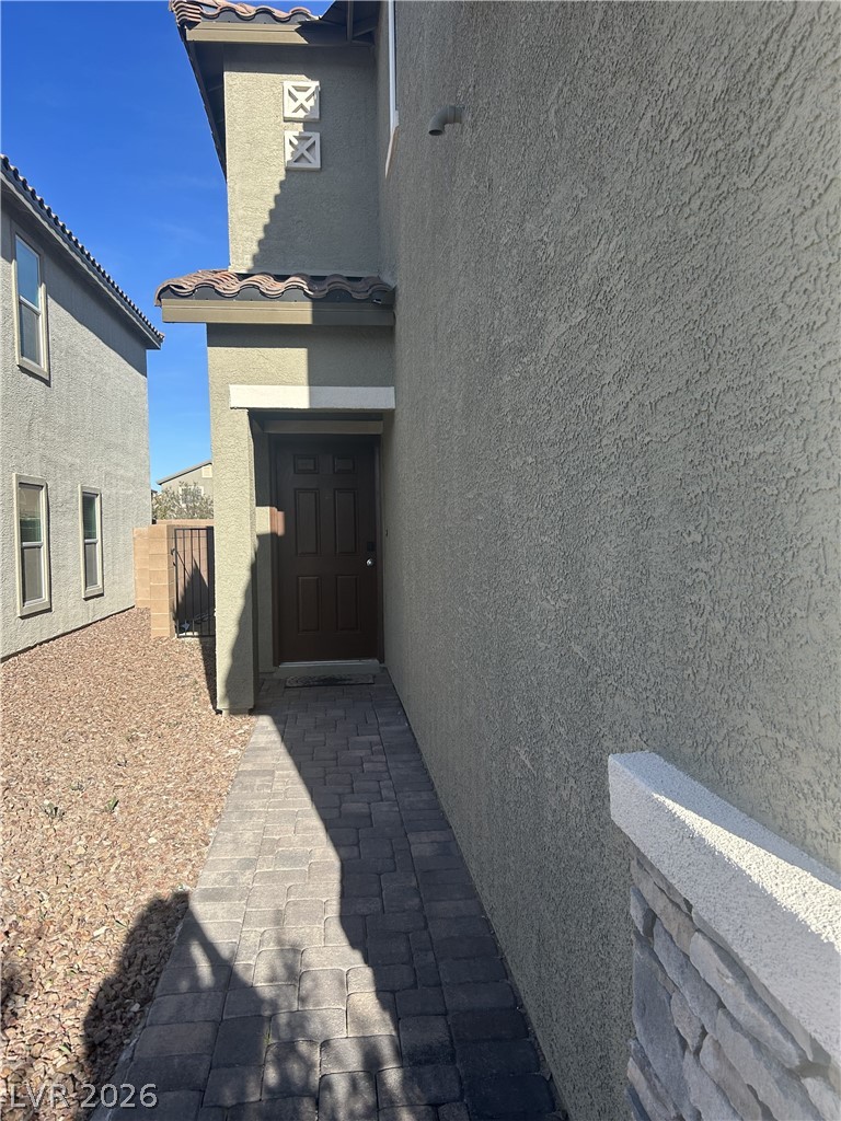10638 Adobe Rnch Street Las Vegas, NV 89141 - Photo 4 of 35 View of exterior entry with stucco siding