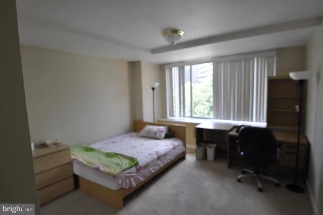 a bedroom with a bed chair and a window