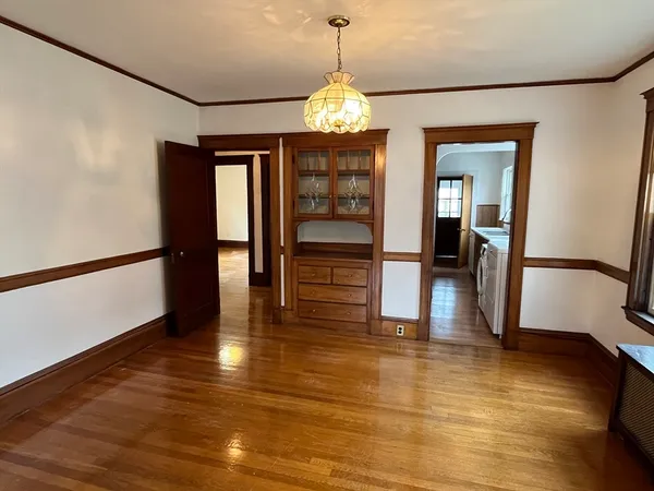 a view of a room with wooden floor staircase and a kitchen