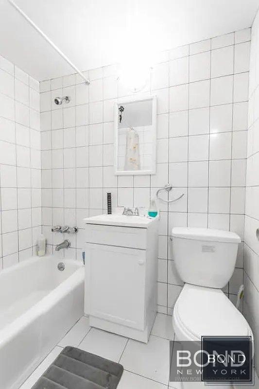 211 Thompson Street, Unit 3E Manhattan, NY 10012 - Photo 6 of 6 a bathroom with a toilet a sink and bathtub