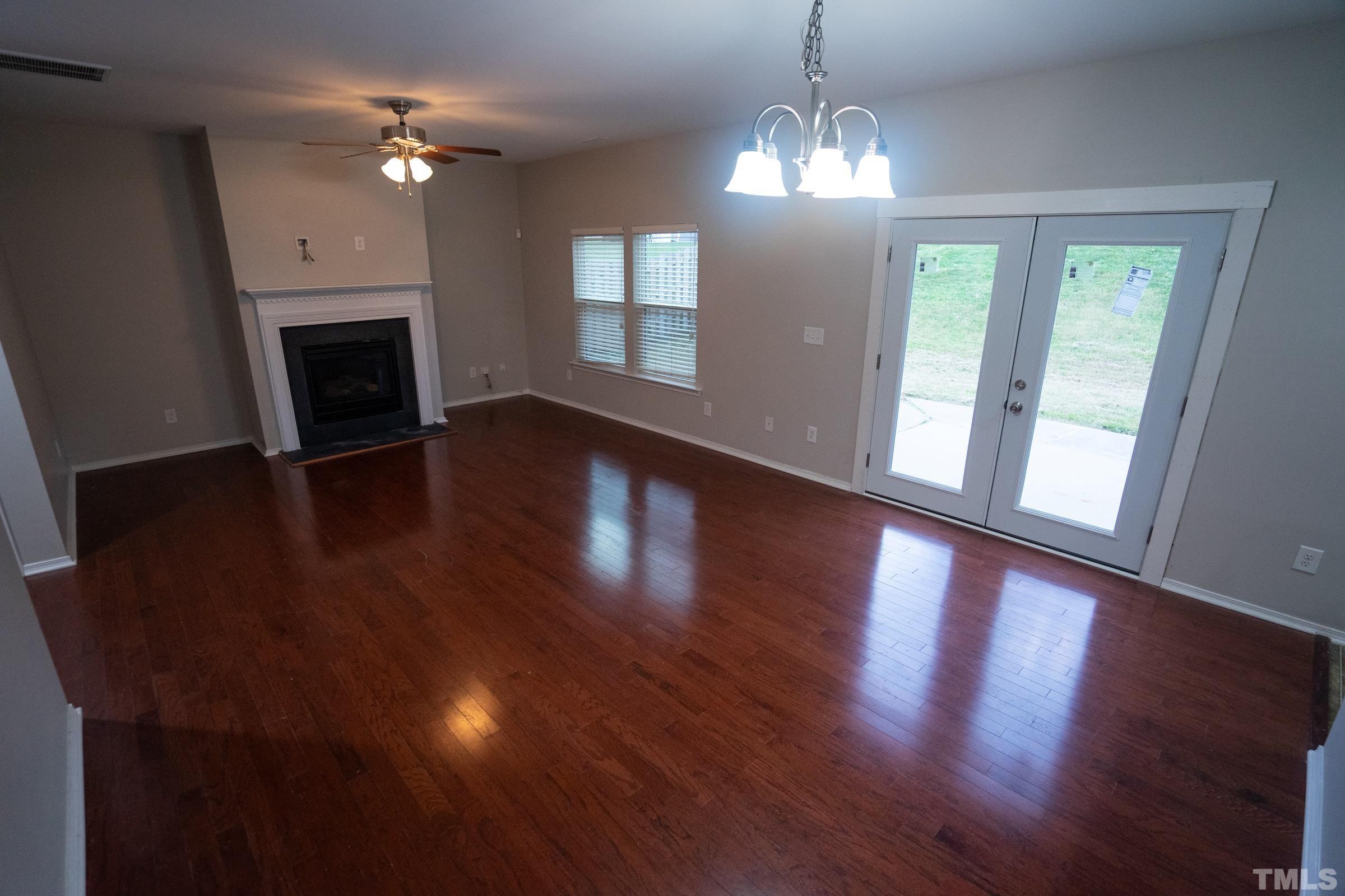 3 Mint Hill Court Durham, NC 27703 - Photo 2 of 19 a view of an empty room with wooden floor fireplace and a window
