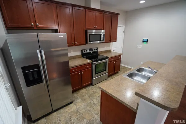 a kitchen with stainless steel appliances granite countertop a refrigerator stove a sink and dishwasher