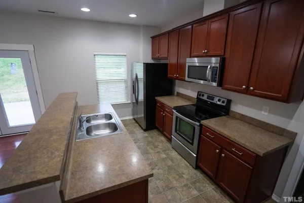 a kitchen with wooden cabinets a sink and a stove