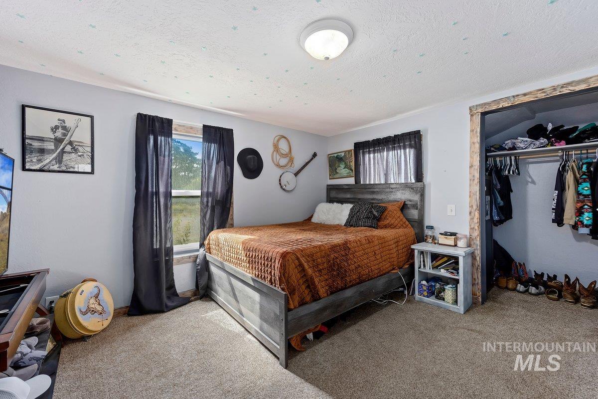 418 South Date Street Shoshone, ID 83352 - Photo 15 of 36 Carpeted room featuring light gray walls, a window with dark drapes, and a built-in closet with hanging space