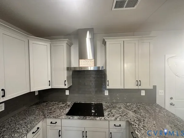 a bathroom with a granite countertop sink and cabinets