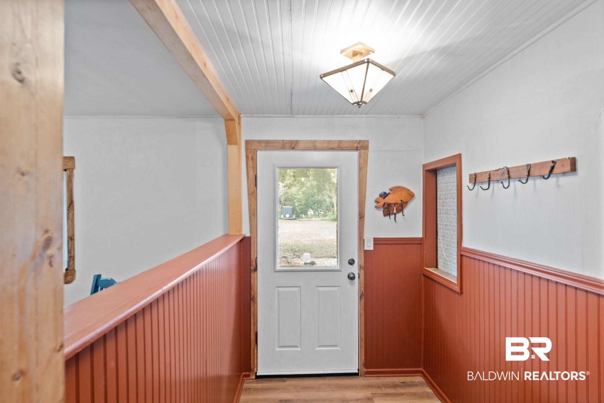 10785 Gregg Road Semmes, AL 36575 - Photo 30 of 35 Doorway to outside featuring wood finished floors, a wainscoted wall, and beamed ceiling