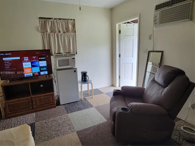 a living room with furniture a flat screen tv and a lamp