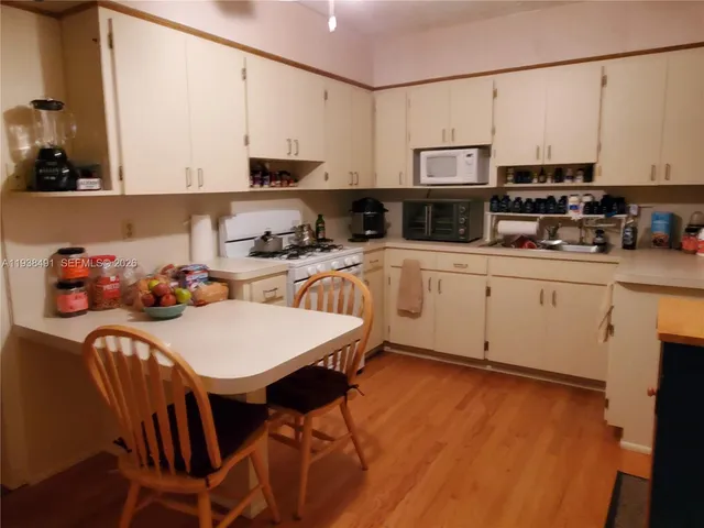 a kitchen with stainless steel appliances granite countertop a stove a sink dishwasher and a refrigerator with wooden floor