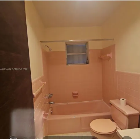 a bathroom with a toilet and a bath tub