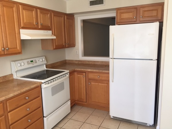 20 F Beal's Cove Road, Unit F Hingham, MA 02043 - Photo 2 of 3 a kitchen with a refrigerator sink and cabinets