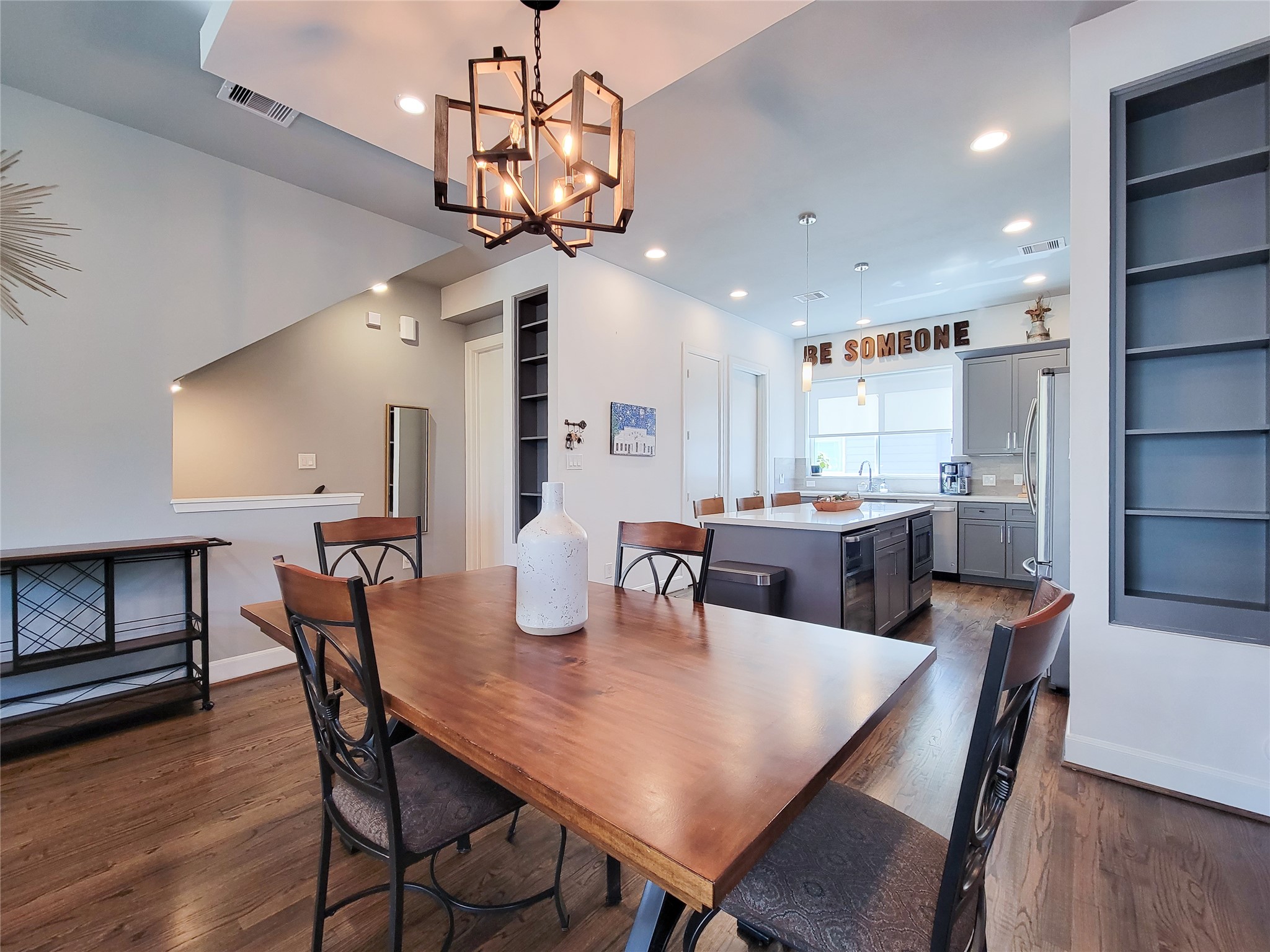 1705 Eado Point Lane Houston, TX 77003 - Photo 22 of 50 This modern dining and kitchen area features sleek hardwood floors, a stylish chandelier, and an open layout. The kitchen boasts an island with bar seating, contemporary cabinetry, and ample natural light. Perfect for entertaining and family gatherings.