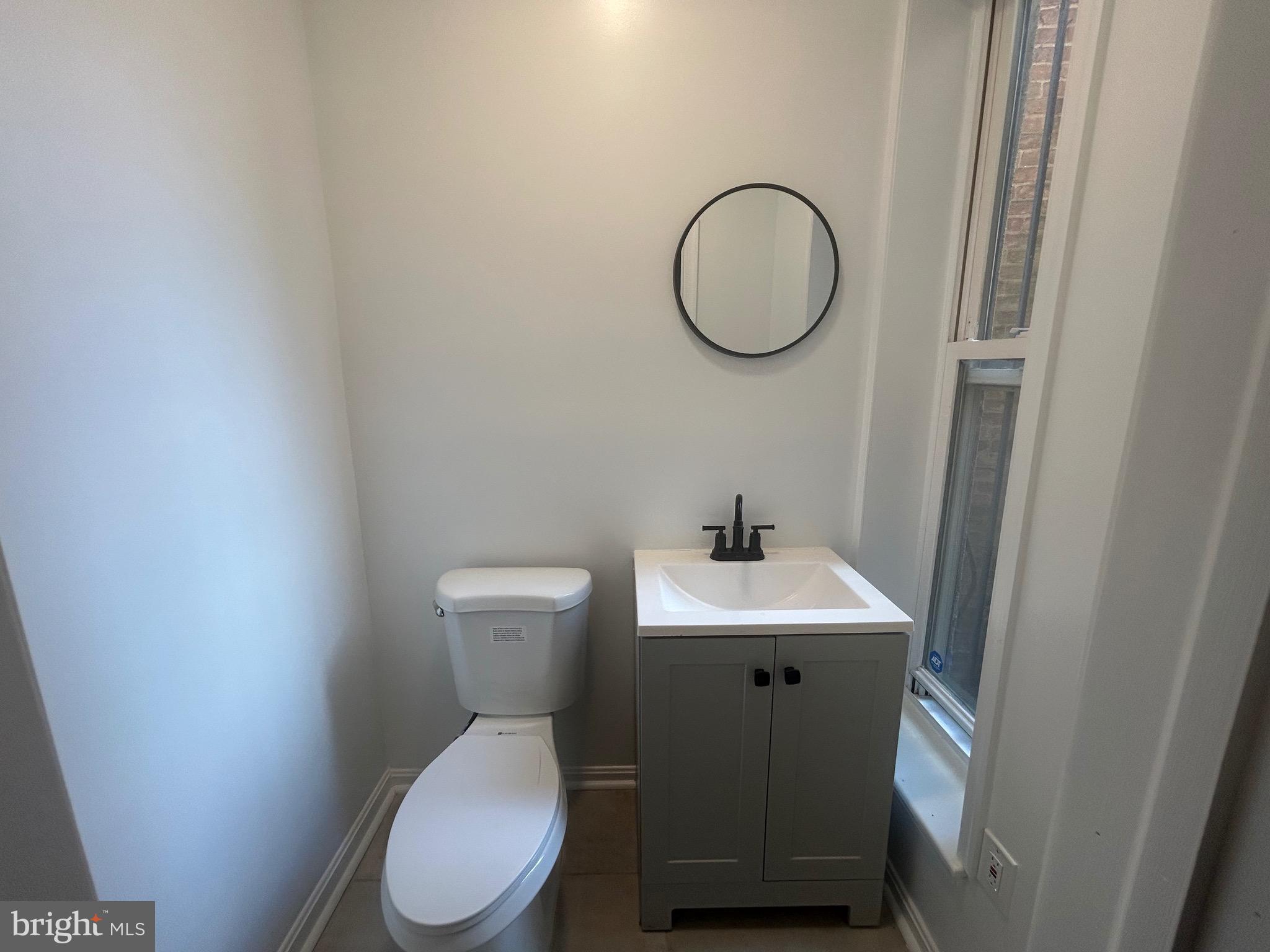 1516 North Mount Street Baltimore, MD 21217 - Photo 12 of 30 a bathroom with a toilet sink and mirror