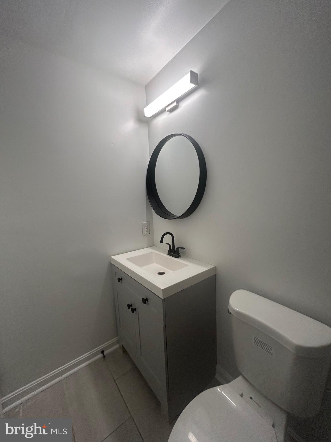1516 North Mount Street Baltimore, MD 21217 - Photo 24 of 30 a bathroom with a toilet a sink and mirror