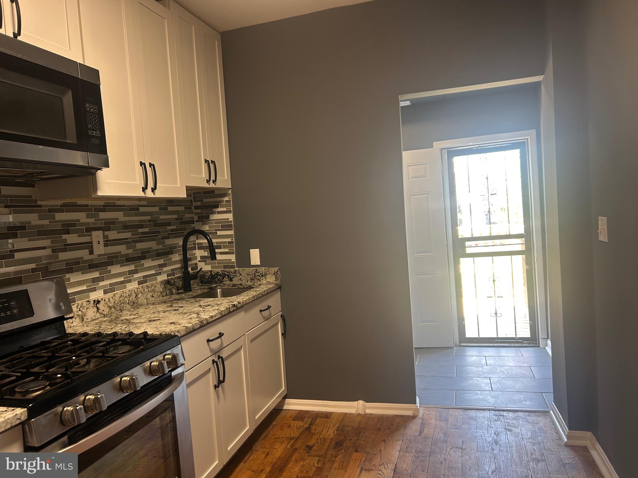 1516 North Mount Street Baltimore, MD 21217 - Photo 28 of 30 a kitchen with a sink stove and microwave