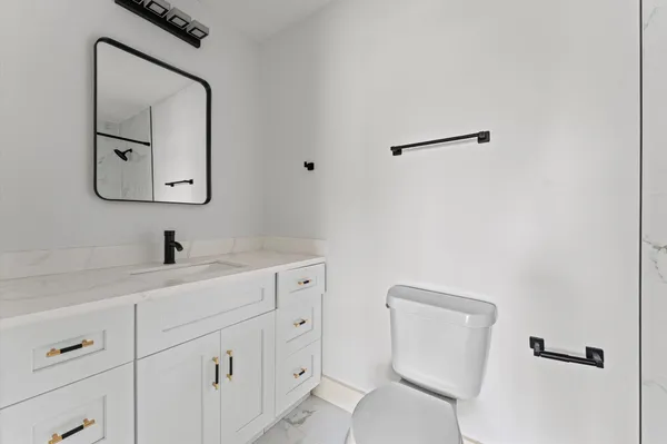 a bathroom with a toilet sink and mirror