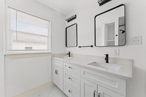 a bathroom with a double vanity sink mirror and