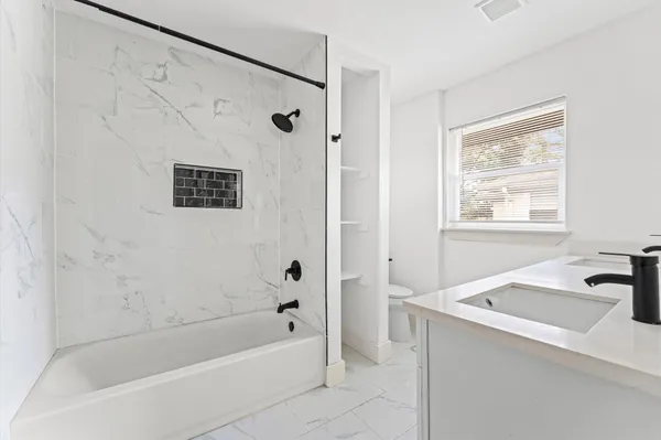 a bathroom with a sink a mirror a bathtub and shower