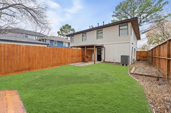 a view of backyard with potted plants and a large tree