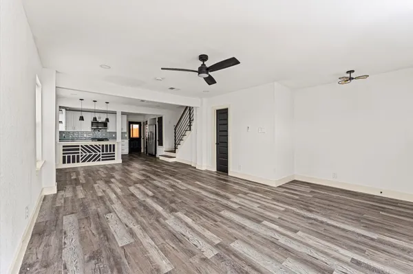 a view of a room with wooden floor and ceiling fan