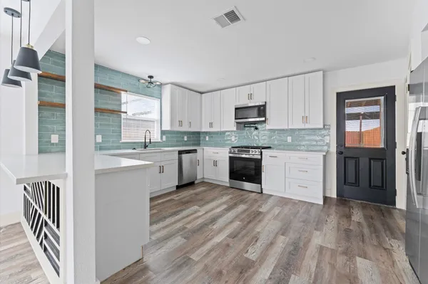 a kitchen with a sink window and cabinets