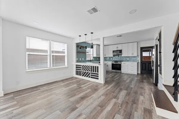 a kitchen with kitchen island wooden floors and stainless steel appliances