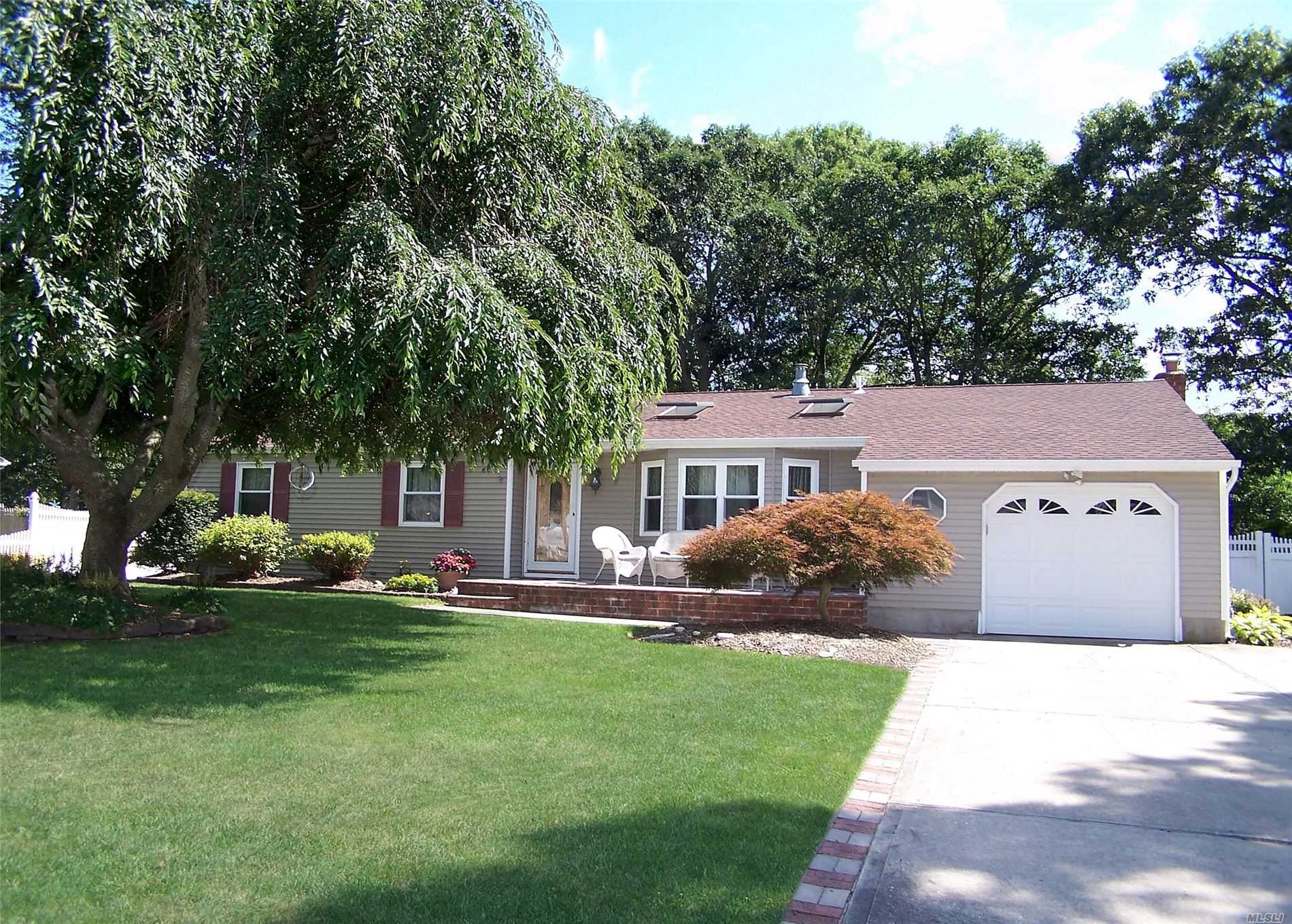 46 Cedar Street Selden, NY 11784 - Photo 1 of 1 a front view of a house with a garden and trees
