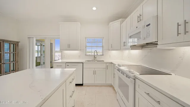 a kitchen with white cabinets and refrigerator