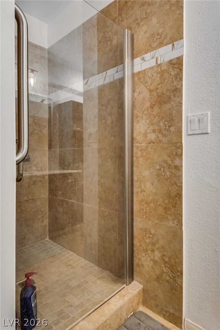 524 Swallow Cove Boulder City, NV 89005 - Photo 25 of 58 A well-appointed shower features glass doors and stylish tile work for an elevated bathing experience.