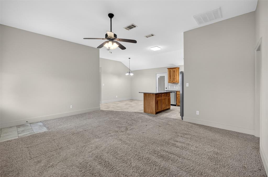 505 East 5th Street Springtown, TX 76082 - Photo 3 of 39 an empty room with chandelier fan and windows
