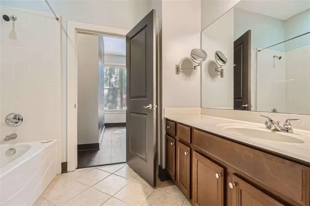 a spacious bathroom with a granite countertop sink a mirror and a bathtub