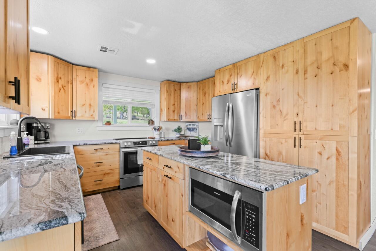 380 Greenleaf Drive Eagle Point, OR 97524 - Photo 16 of 31 a kitchen with granite countertop a sink stainless steel appliances and cabinets