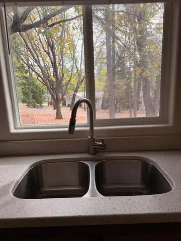 a view of a house with backyard and a tree