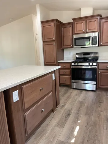 a view of a wooden house with a small yard and wooden fence
