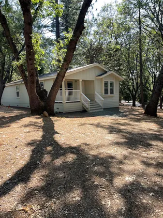 a kitchen with stainless steel appliances granite countertop a refrigerator a sink a stove and a refrigerator with wooden cabinets