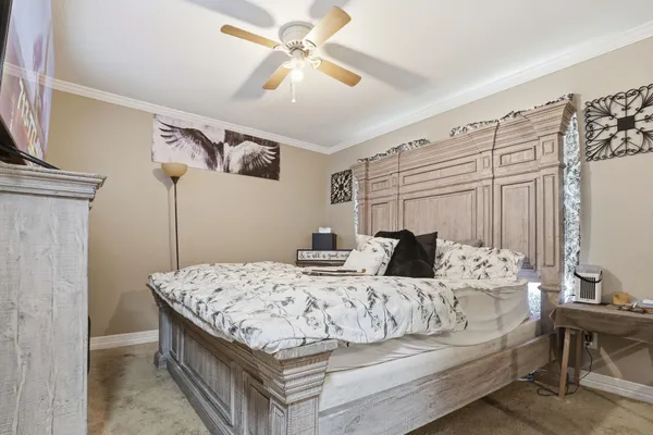 a bedroom with a large bed and a chandelier