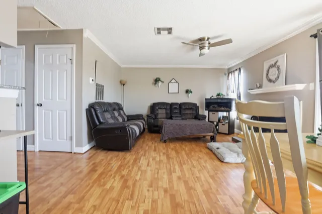 a living room with furniture and a wooden floor