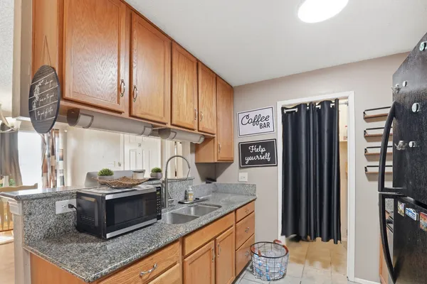 a kitchen with granite countertop a refrigerator stove and sink