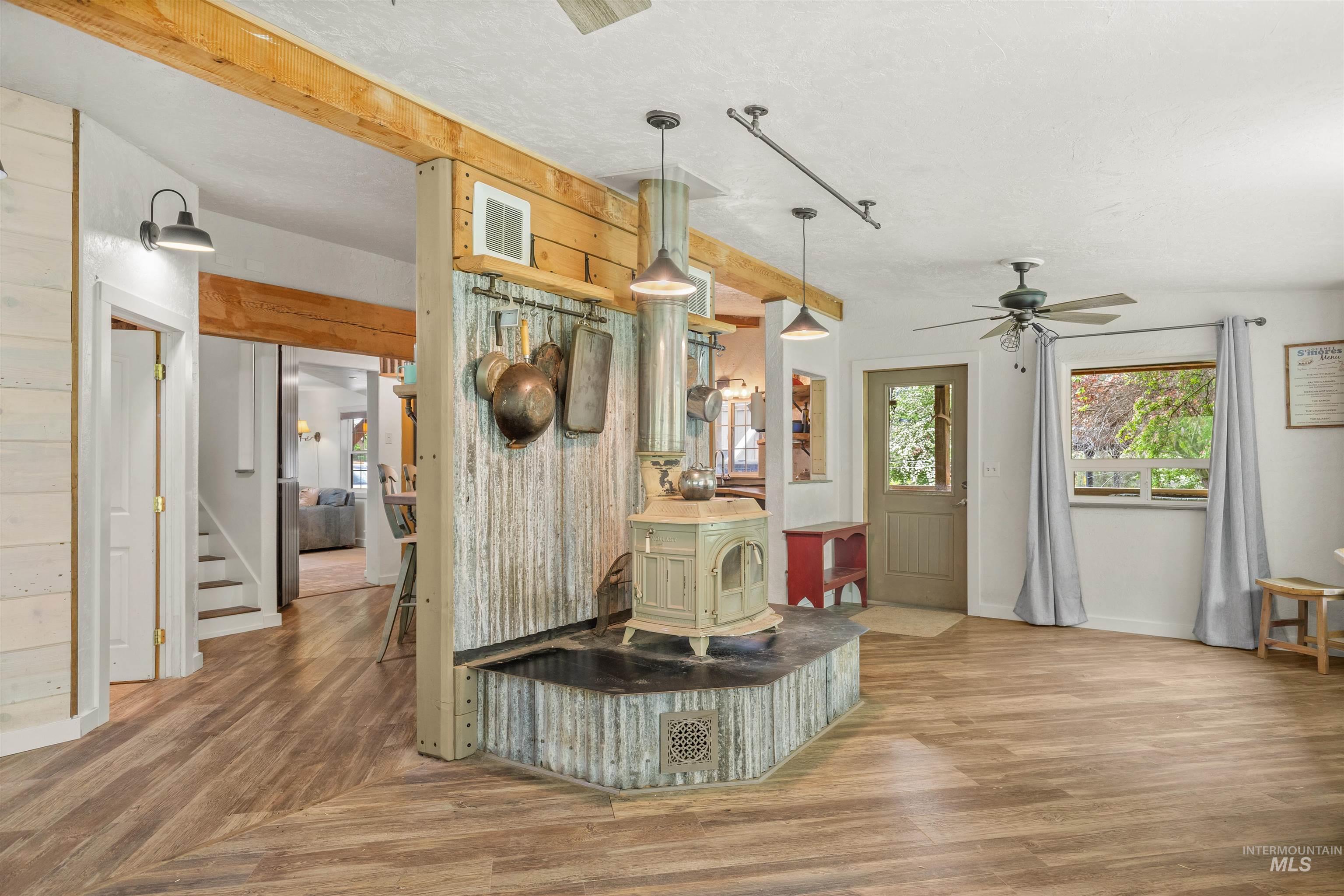 1314 Cedar Ridge Road Kendrick, ID 83537 - Photo 22 of 50 Central wood stove on a corrugated metal hearth, flanked by wood-finish flooring
