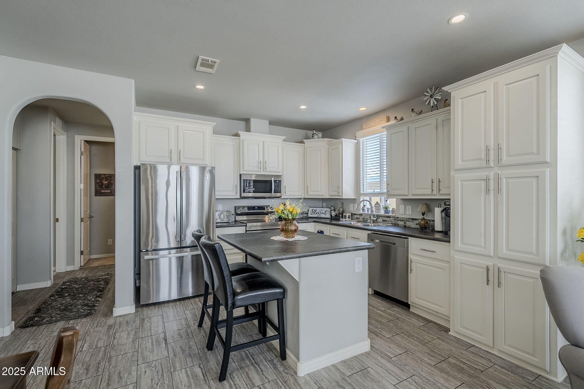 650 North Hawes Road, Unit 3215 Mesa, AZ 85207 - Photo 11 of 68 a kitchen with stainless steel appliances a refrigerator a sink a stove a table and chairs