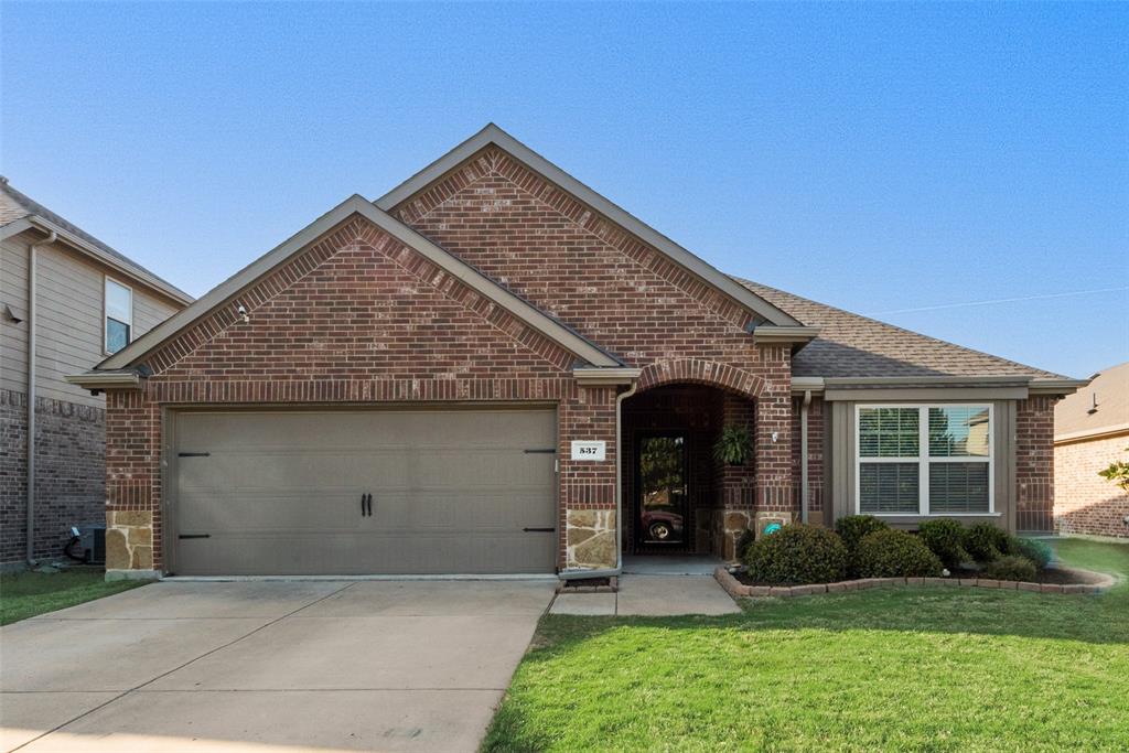 537 Haven Drive Anna, TX 75409 - Photo 1 of 1 Ranch-style home featuring driveway, a front lawn, brick siding, a garage, and a shingled roof