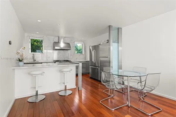a kitchen with kitchen island white cabinets and stainless steel appliances